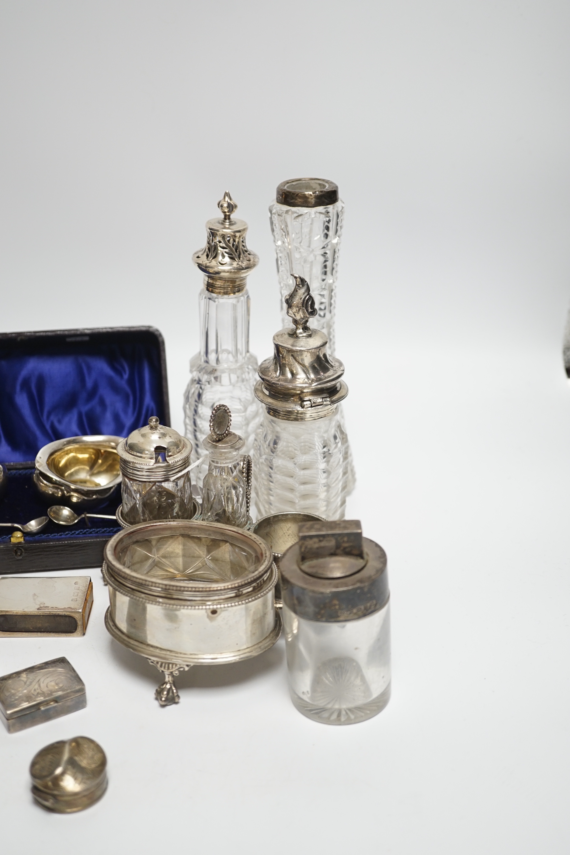 Sundry small silver including a Victorian silver cruet stand, London, 1858 (lacking one bottle), two salts, a vesta case, pill boxes, pair of sugar tongs, two cased pairs of salts with spoons, five mounted glass bottles,